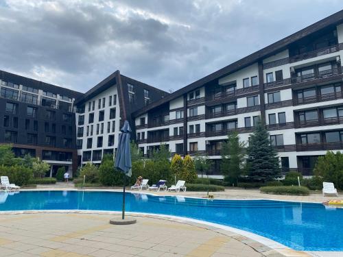 a large apartment building with a large swimming pool at Cosy studios with mountain view near Bansko in Razlog