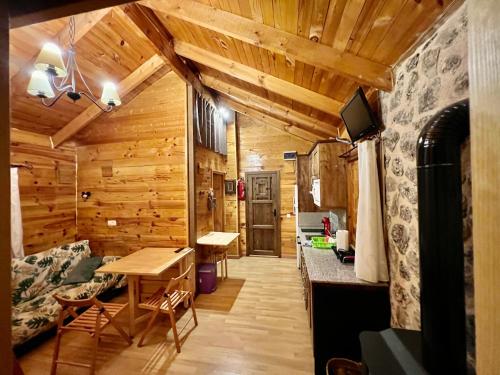 Zimmer mit Holzwänden und einem Esszimmer mit einem Tisch in der Unterkunft Casa Rural Campanilla in Riópar