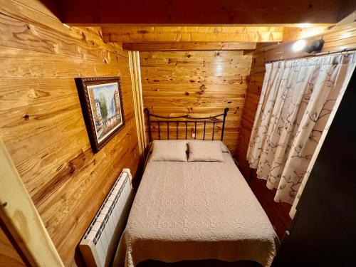 a small bedroom with a bed in a log cabin at Casa Rural Campanilla in Riópar