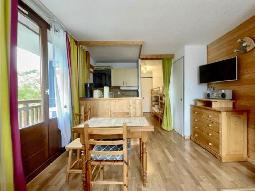 une cuisine avec une table en bois et une salle à manger dans l'établissement Studio au centre, 4 pers, proche remontées, balcon ouest, équipements complets - FR-1-572-262, à Arâches-la-Frasse