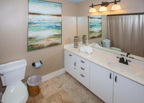 a bathroom with a sink and a toilet and a mirror at The Palms 313A in Orange Beach