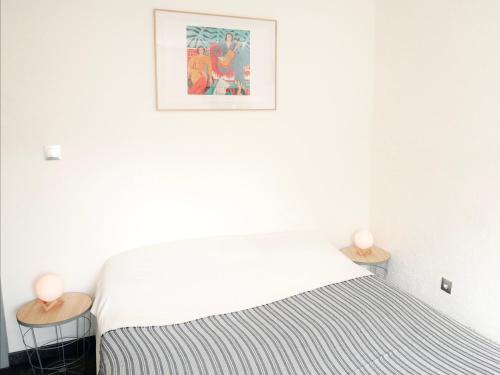 ein weißes Schlafzimmer mit einem Bett und 2 Tischen in der Unterkunft Appartement unique sur Stiring Wendel avec Balcon in Stiring-Wendel