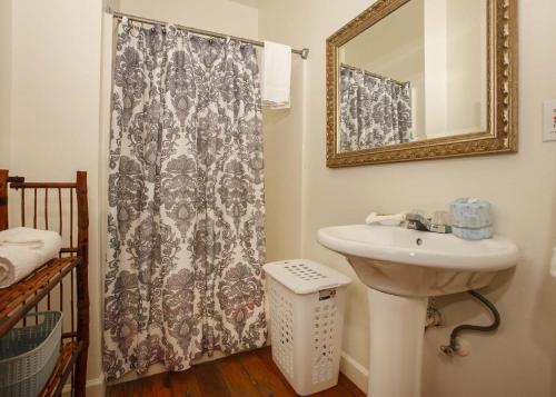 a bathroom with a sink and a shower curtain at Porch Lane Cottage F in Fairhope