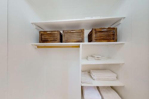 un armario con estanterías y cestas blancas en Lake City Charmer, en Coeur d'Alene