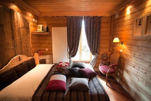 a bedroom with a bed in a log cabin at Logis hôtel Arbez Franco Suisse in Les Rousses