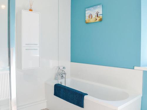 a bathroom with a tub and a sink and a mirror at West Lanegate Farmhouse in Amisfield Town