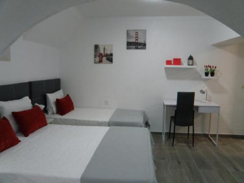 a bedroom with a bed and a table and a desk at Residencial Antonio Mocisso Guesthouse in Elvas