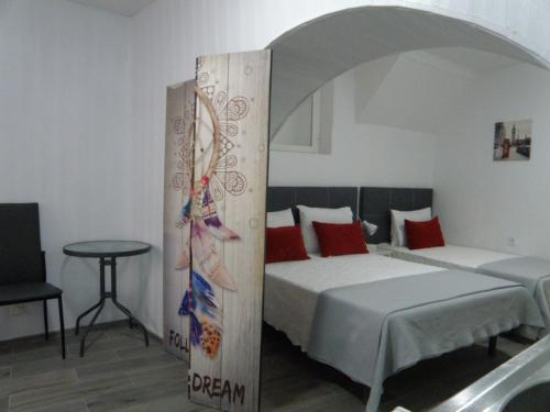 a bedroom with two beds and a table in it at Residencial Antonio Mocisso Guesthouse in Elvas