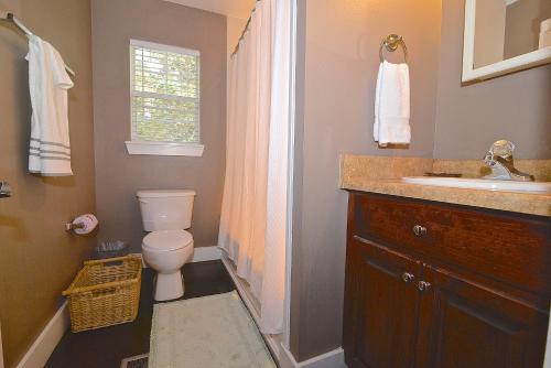 a bathroom with a toilet and a sink at Porch Lane Cottage C in Fairhope