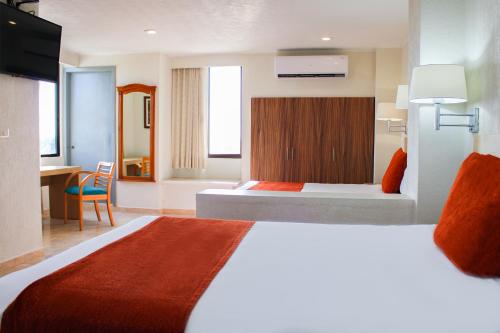 a hotel room with a large bed and a desk at Hotel & Suites Real del Lago in Villahermosa