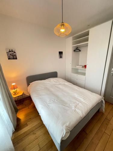 1 dormitorio con 1 cama blanca y 1 lámpara en Le Domaine Des Yèbles - Appartement Calme et élégant, en Avon