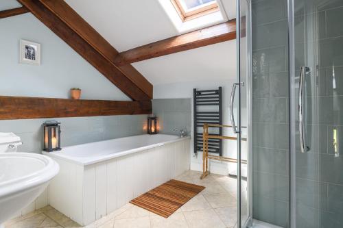 a bathroom with a bath tub and a shower at Carrholme Cottage in Settle