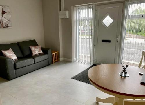 uma sala de estar com um sofá e uma mesa em Erne Getaway No.5 Brand new 1 bed apartment em Enniskillen