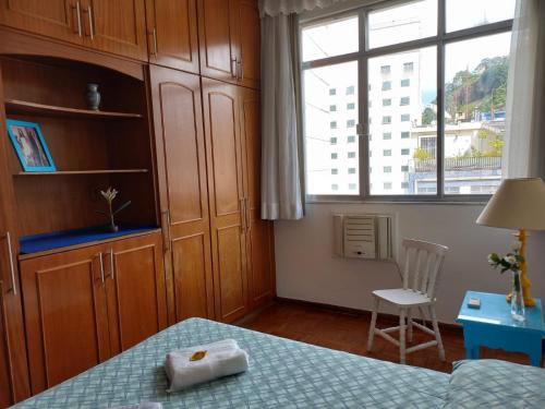 1 dormitorio con cama, ventana y silla en Charming Studio Copacabana Beach & Metro, en Río de Janeiro