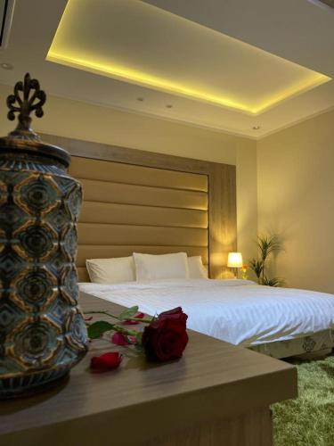 a bedroom with a bed with roses on a table at Royal AlUla Villa in Al-ʿUla