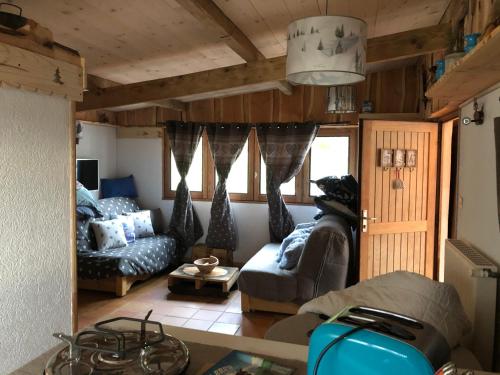 ein Wohnzimmer mit einem Sofa und einem Tisch in der Unterkunft LE CHALET de la goutte in Saint-Appolinaire