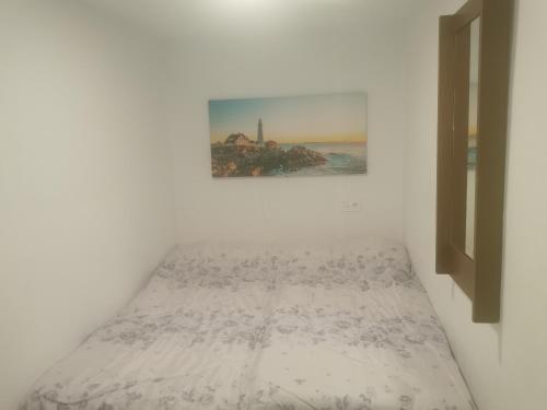 1 cama en una habitación con una foto en la pared en casa luna cuesta del rio 15, en Valdeganga