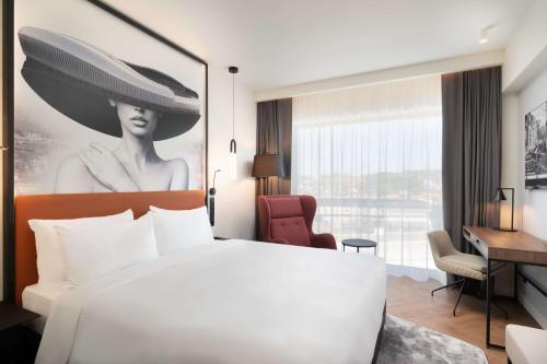 a hotel room with a white bed and a desk at Radisson Blu Hotel, Cluj in Cluj-Napoca