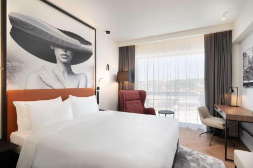 um quarto de hotel com uma cama branca e uma secretária em Radisson Blu Hotel, Cluj em Cluj-Napoca