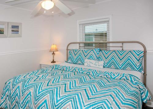 a bedroom with a bed with a blue and white bedspread at Breaking Even House in Fort Morgan