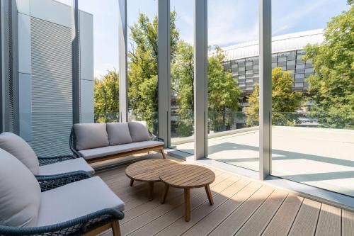 a room with a couch and a table and windows at Radisson Blu Hotel, Cluj in Cluj-Napoca