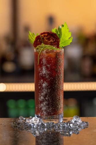 a drink sitting on a table with a garnishment at Radisson Blu Hotel, Cluj in Cluj-Napoca