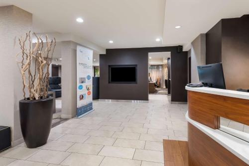 a lobby with a reception desk and a tv at Sonesta Select Tempe Downtown in Tempe