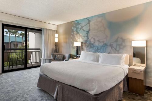 a hotel room with a large bed and a balcony at Sonesta Select Tempe Downtown in Tempe