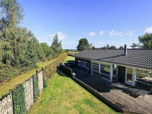 a house with a wooden deck and a fence at 8 person holiday home in Otterup in Otterup