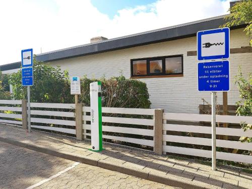 a building with signs in front of a fence at 4 person holiday home in r sk bing in Ærøskøbing