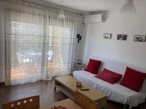 a living room with a white couch and red pillows at Apartamento Las Chumberas in Roquetas de Mar