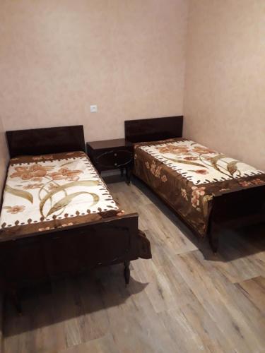 two beds sitting in a room with wooden floors at Apartment in the city center in Tbilisi City