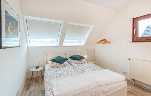 a bedroom with a bed and two windows at 2 Bedroom Gorgeous Home In Hennstedt in Hennstedt