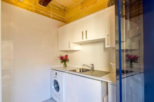 a kitchen with a sink and a washing machine at Dar Il-Bahar Holiday home in San Lawrenz