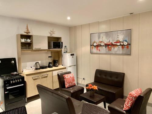 een woonkamer met een bank en een keuken bij Suite 1ra Fila Vista Bahía - 100 Metros Las Velas 601 T1 in Paracas