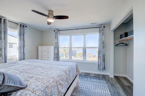 um quarto com uma cama e uma grande janela em Sunsets and Seashells em North Topsail Beach