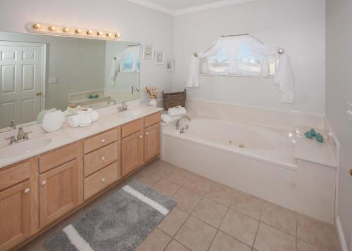 a bathroom with a tub and a sink and a bath tub at Shiloh House in Fort Morgan