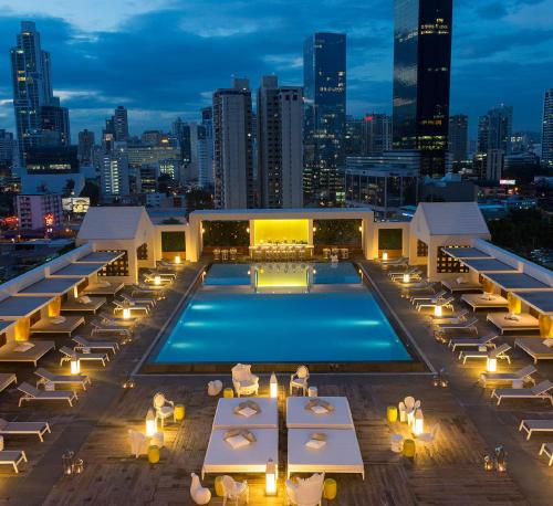 a pool on the roof of a building with a city skyline at Yoo Panama in Panama City