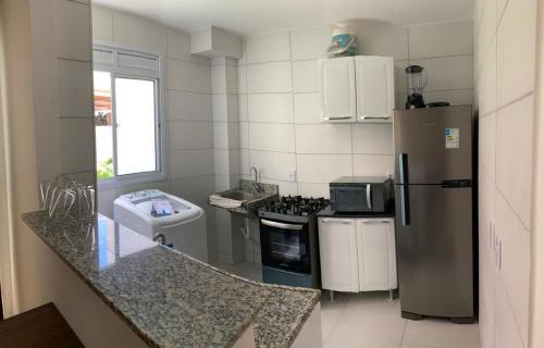 eine kleine Küche mit Kühlschrank und Spüle in der Unterkunft Apto em João Pessoa wifi e ar condicionado in João Pessoa