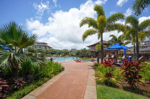 um resort com piscina e palmeiras em Pili Mai III em Koloa
