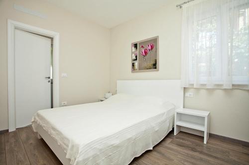 een witte slaapkamer met een wit bed en een raam bij Apartments with a parking space Rovinj - 3393 in Rovinj