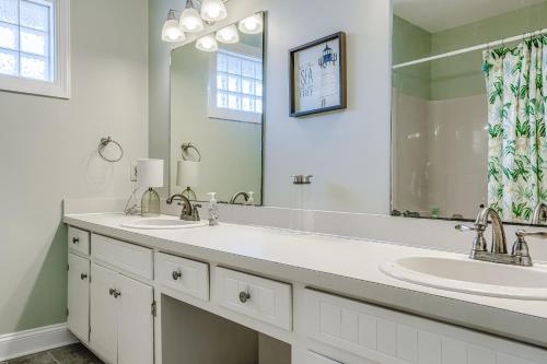 a bathroom with two sinks and a large mirror at Slow Your Roll in Topsail Beach