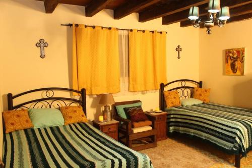 a bedroom with two beds and a chair and a window at Rustic Luxury Retreat Near Historic Zacatlan in Zacatlán