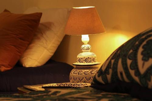 a lamp sitting on a table next to a bed at Rustic Luxury Retreat Near Historic Zacatlan in Zacatlán