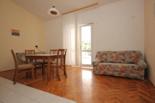ein Wohnzimmer mit einem Sofa, einem Tisch und einem Stuhl in der Unterkunft Apartments by the sea Zaglav, Dugi otok - 8145 in Zaglav