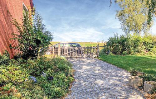 a driveway with a fence and a car on a bridge at 1 Bedroom Gorgeous Home In Basbellain in Basbellain