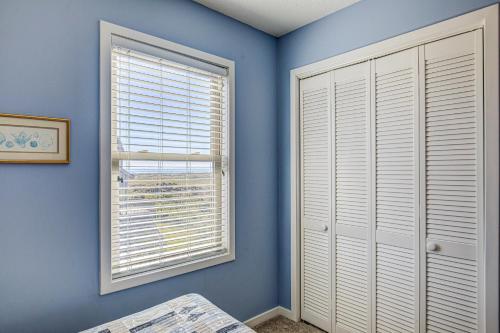 a bedroom with blue walls and a window at Baylin A in Topsail Beach