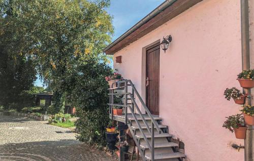 a pink building with a staircase next to a door at 1 Bedroom Lovely Home In Basbellain in Basbellain