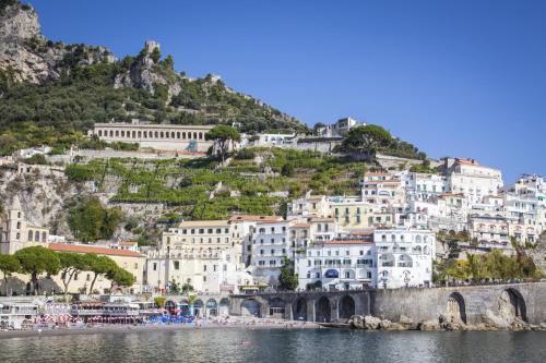a group of buildings on a hill next to a body of water at Hotel Marina Riviera in Amalfi