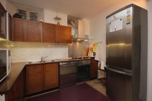 La cuisine est équipée d'armoires en bois et d'un réfrigérateur en acier inoxydable. dans l'établissement Seaside holiday house Cavtat, Dubrovnik - 8557, à Cavtat